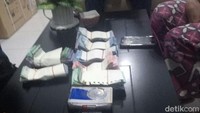 Petugas Linmas Kecamatan Tambaksari yang menemukan Asnan di Jl Teratai Tambaksari, menghitung uang itu. Totalnya Rp 48.970.00. (Foto: Istimewa)