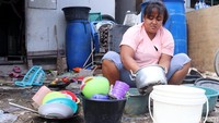 Warga mencuci peralatan rumah tangga. Sulitnya air bersih membuat sebagian warga mencuci menggunakan air hujan.