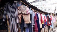 Jajaran pakaian yang dijemur di teras rumah warga.