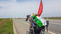 Benjamin berjalan kaki dengan sebuah stroller bayi berisi kebutuhannya (walktopalestine/Instagram)