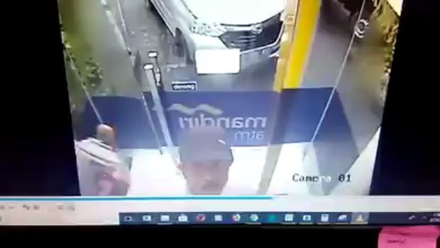 Pria ini memperlihatkan gerak-gerik mencurigakan di bilik mesin ATM di Mojokerto. (Foto: Enggran Eko Budianto)