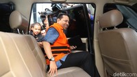 Ia langsung menuju mobil tahanan sambil membawa sebuah buku berwarna hitam.