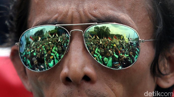Massa driver ojek online (ojol) masih berdemonstrasi di depan Istana Negara, Jakarta, Selasa (27/3/2018). Mereka menyuarakan tuntutan soal rasionalisasi tarif ojol. Massa juga menuntut legalitas angkutan online kendaraan roda dua.