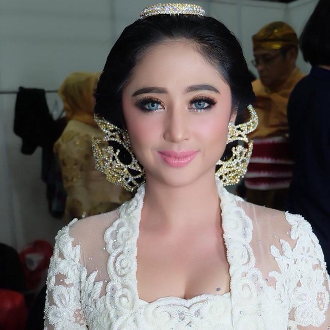 Dewi Persik menjelma menjadi wanita ayu di resepsi pernikahannya dengan Angga Wijaya. Makeup artist Andruw Spun menerapkan gaya riasan flawless dengan lipstik pink yang membuat Depe, begitu Dewi Persik biasa disapa, terlihat seperti boneka Barbie. Foto: Instagram @dewiperssikreal