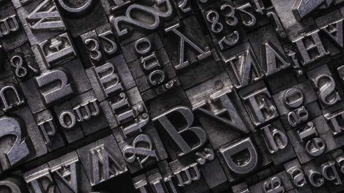 A background from many historic typographical letters in black and white with white background.