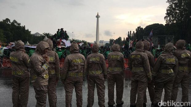 Massa driver ojek online bertahan di tengah guyuran hujan di depan Istana, Selasa (27/3/2018)