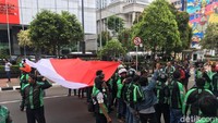 Massa demo ojek online juga mengibarkan bendera merah putih