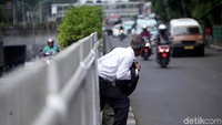 Meski berbahaya warga nekat menerobos pagar pembatas untuk memperpendek jarak tempuh.