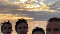 Potret David Beckham bersama 3 putranya saat berenang dengan menikmati sunset di belakangnya (davidbeckham/Instagram)