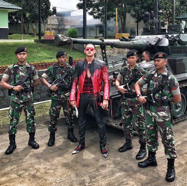 Arnold Putra bahkan pernah melakukan pemotretan bersama para prajurit TNI. Dia memakai busana karya Haider Ackermann saat berpose di antara para tentara dan tank.Foto: Instagram Arnold Putra