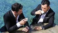Menggunakan jas, Arifin dan rekannya ngopi di Bali sebelum syuting. Pemandangan laut di belakangnya bikin ngopi jadi lebih istimewa. Foto: Instagram arifinputra_