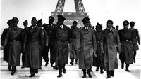 Diktator Jerman Adolf Hitler saat berada di Menara Eiffel bersama dengan para jendralnya selama pendudukan Jerman di Prancis. Turut serta pematung Arno Breker (kiri) dan arsitek Albert Speer (kanan). (dok. Harwood/Keystone/Getty Images)