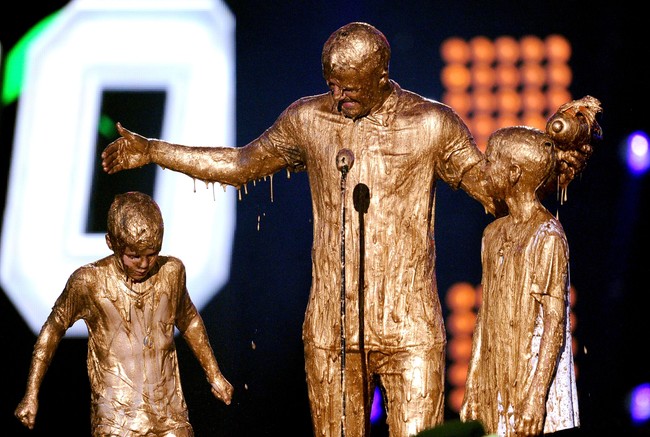 Kalau ini, gaya kompak Beckham saat berbalur lendir emas bersama kedua putranya di panggung Nickelodeon Kids Choice Sports Awards 2014. (Foto: Getty Images)