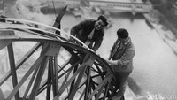 Dua tukang listrik memeriksa kesiapan lampu Menara Eiffel yang akan menerangi Pameran Paris di malam hari. (dok. Horace Abrahams/Getty Images)