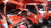 Sebagian truk rusak di bagian depan. Kepala truk ringsek hingga kaca pecah.