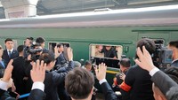 Kim Jong Un tampak melambaikan tangan dari dalam kereta