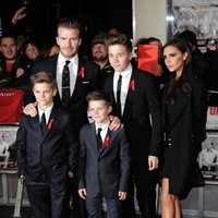 Begini gaya David Beckham sekeluarga yang kompak mengenakan setelan jas di karpet merah premier The Class of 92 di London, Desember 2013. Sementara itu, istrinya, Victoria Beckham anggun dengan little black dress berpadu coat senada. (Foto: Getty Images)