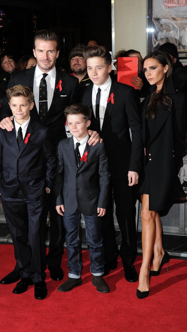 Begini gaya David Beckham sekeluarga yang kompak mengenakan setelan jas di karpet merah premier The Class of 92 di London, Desember 2013. Sementara itu, istrinya, Victoria Beckham anggun dengan little black dress berpadu coat senada. (Foto: Getty Images)