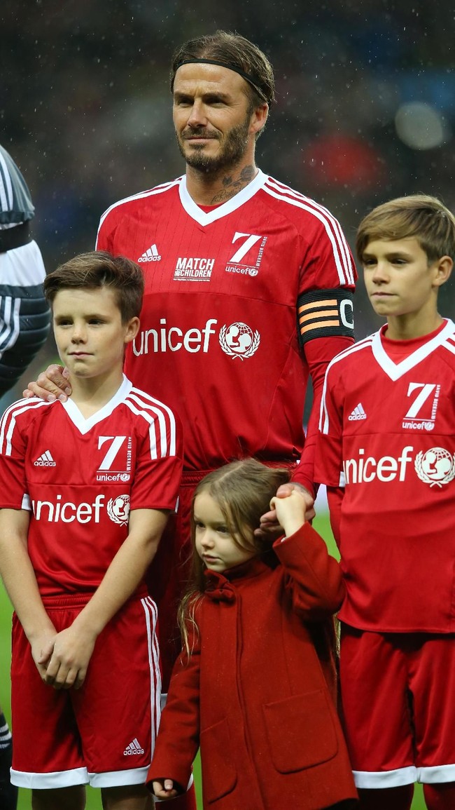 Di lapangan hijau pun, David Beckham kompak dengan kedua putranya, Cruz dan Romeo dengan jersey merah bernomor punggung tujuh (nomor favorit Beckham) saat pertandingan amal pada 2015 silam. Tampak pula si bungsu Harper yang berbalut coat merah. (Foto: Getty Images)