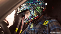 Rossi duduk di kemudi mobil dengan mengenakan helm berdesain khasnya. Foto: Instagram/Ferrari