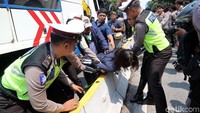 Ketegangan terjadi karena polisi hendak menderek mobil para driver taksi online yang diparkir di Jalan Medan Merdeka Barat.