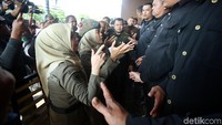 Personel Satpol PP berdiri di depan para sekuriti yang berbaris membentuk pagar betis.