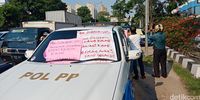 Mobil Satpol PP sempat ditempeli poster protes oleh para eks karyawan Alexis