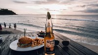 Menghabiskan waktu di Bali paling enak menikmati sunset. Tentunya ditemani burger, kentang goreng dan bir. Lengkap ya kebahagiaan Kevin. Foto: Instagram kevinjulio1993