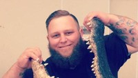 Mike Kliebert dengan berani memegang mulut aligator.