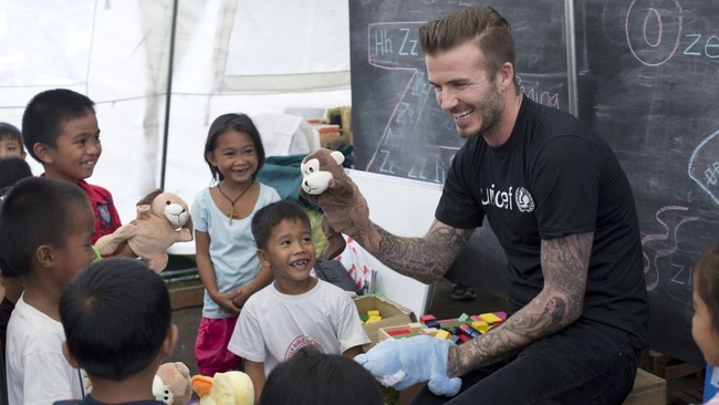 Mengunjungi korban topan Haiyan di Filipina pada 2005, David Beckham mengajak bermain anak-anak yang menjadi korban bencana itu. Dia tertawa bersama mereka saat bermain boneka tangan. Foto: Dok. UNICEF