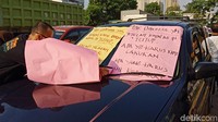 Seorang karyawan lalu membawa poster-poster itu ke mobil Satpol PP.
