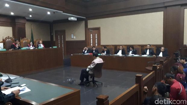 Novanto memejamkan mata dan tertunduk ke bawah duduk di bangku terdakwa di Pengadilan Tipikor