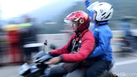 Pengendara sepeda motor mengabadikan lokasi longsor menggunakan hanphone.