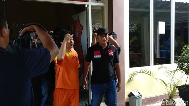 Iwan saat didampingi polisi kembali ke tahanan