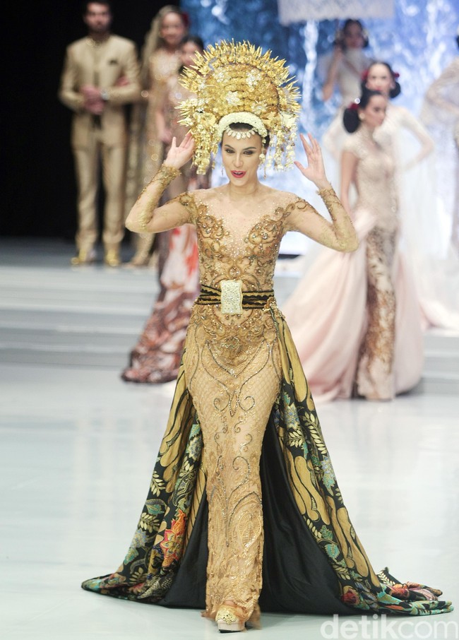 Dengan hiasan kepala dan gaun yang semegah itu, Sophia Latjuba terlihat melangkah dengan hati-hati.  Walau sempat hampir terjatuh, perempuan 47 tahun itu tetap sukses menebar pesonanya. Foto: Muhammad Abduh/Wolipop