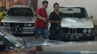  Dari balik mobil, terlihat pengunjung antusias memperhatikan mobil jadul yang dipamerkan.