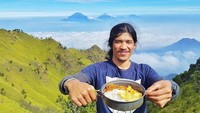 Pendaki ini memamerkan menu sarapannya nih. Ada nasi, mie goreng dan telur. Sederhana sih tapi coba lihat pemandangan di belakangnya. Keren kan? Foto : instagram @dennykoesmawan