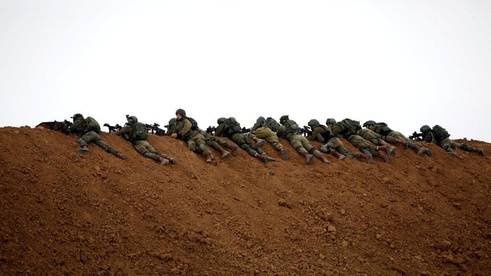 Israeli soldiers are seen next to the border fence on the Israeli side of the border with the northern Gaza Strip, Israel, March 30, 2018. REUTERS/Amir Cohen     TPX IMAGES OF THE DAY