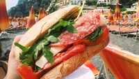 Tidak hanya foto makanannya saja yang membuat Anda lapar, tapi latar belakangnya yang indah justru semakin menarik perhatian. Seperti foto sandwhich yang diambil di Almafi Coast, Italia. Foto: Instagram @foodintheair