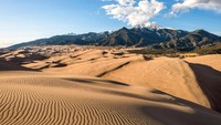 Latar pemandangan dari gurun pasirnya adalah Pegunungan Rocky, dengan puncak-puncak yang cadas dan tertutup es! (Great Sand Dunes National Park and Preserve/Facebook)