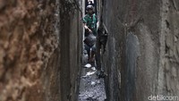 Seorang warga melintasi sela-sela pemukiman padat penduduk di lokasi kebakaran.