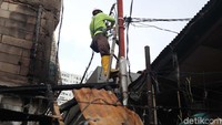 Seorang petugas PLN memeriksa kondisi kabel listrik di lokasi kebakaran 
