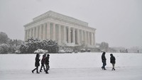 Foto:  Pada bulan Maret, para pengunjung berkumpul di luar The Lincoln Memorial di ibu kota AS, Washington DC. Terlihat salju tebal dan angin berhembus (Mandel Ngan/CNN Travel)