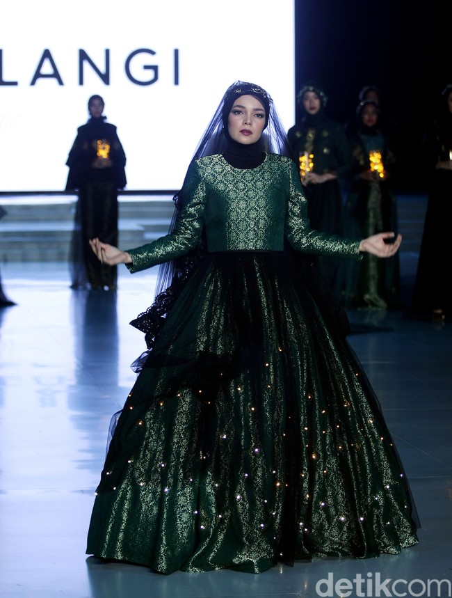 Dewi Sandra menjadi muse pertunjukan Dian Pelangi dan Restu Anggraini. Ia tampil seperti boneka saat memakai gaun glowing in the dark karya Dian Pelangi. Foto: Mohammad Abduh/Wolipop