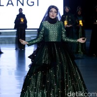 Dewi Sandra menjadi muse pertunjukan Dian Pelangi dan Restu Anggraini. Ia tampil seperti boneka saat memakai gaun glowing in the dark karya Dian Pelangi. Foto: Mohammad Abduh/Wolipop