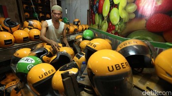 Pedagang menata helm-helm bekas ojek online.