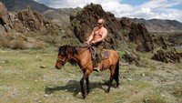 Meskipun politisi kawakan, Putin suka traveling. Dia suka aneka outdoor activity yang jantan dan macho seperti berkuda sambil telanjang dada di Siberia tahun 2009 (Alexei Druzhinin/Reuters)