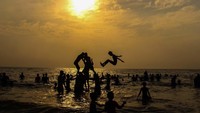 Foto: Sekelompok wisatawan membentuk piramida manusia saat matahari terbenam di Pantai Juhu Mumbai, India pada 25 Maret. Tercatat suhu terpanas di salah satu hari di bulan Maret, yakni 41 derajat celcius (Pramod Thakur/CNN Travel)