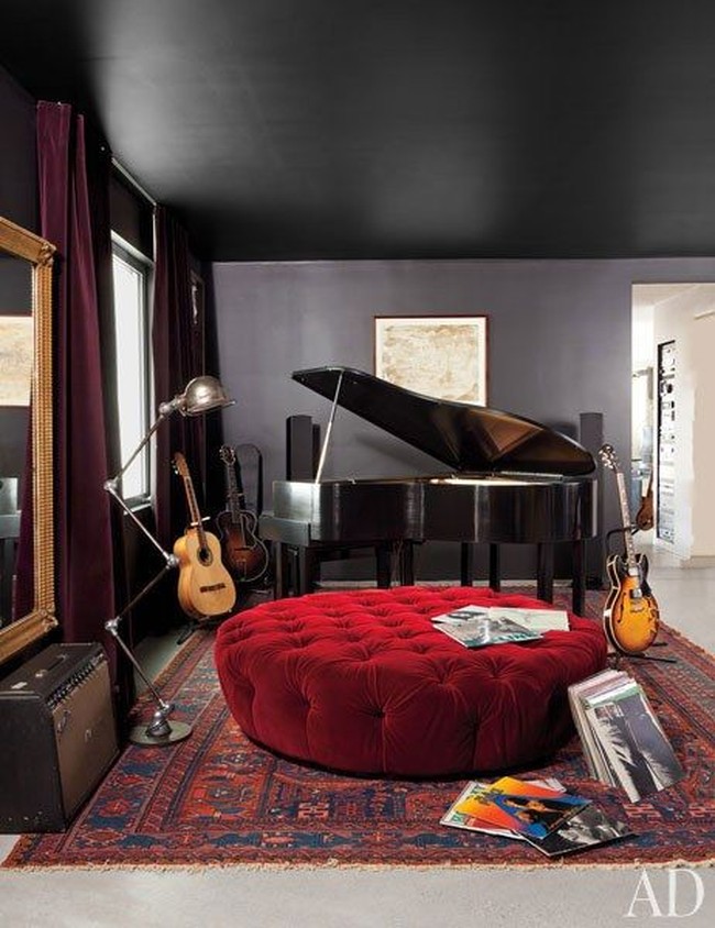 Salah satu sudut area kamar utama yang dilengkapi baby grand piano dari Wurlitzer yang kontras dengan sofa bundar merah di depannya. Foto: Dok. Architectural Digest
