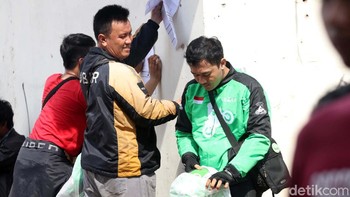 Senyum driver melihat rekannya mendapatkan jaket dan helm Go-Jek.